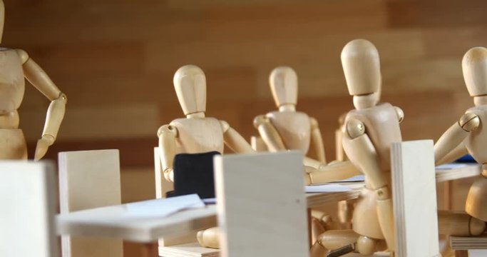 Wooden figurines having meeting in conference room