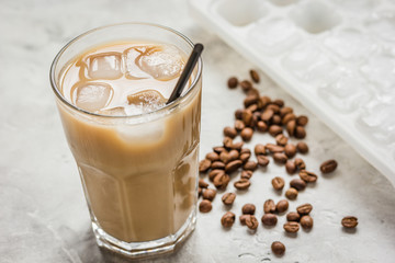 Ice coffee with milk and beans for lunch on stone background