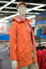 Obraz premium Mannequin with orange winter jacket on it in outdoor clothes store