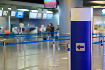 Information stand in front of waiting lines near check in desks in airport