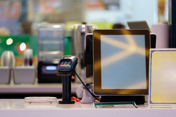 Cash and order desk with large screen in small cafe in mall
