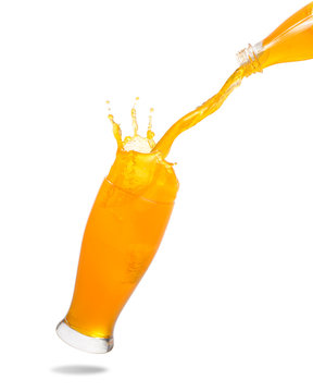 Pouring orange juice from bottle into glass with splashing isolated on white background.