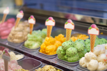 Variety of fruit ice cream for bowls in containers in fridge