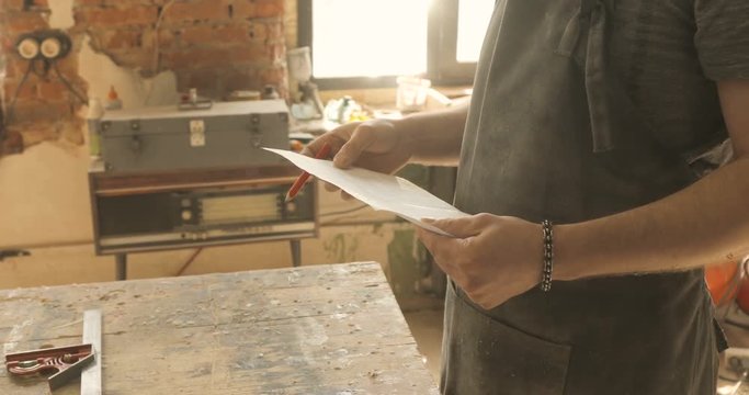 Carpenter working on a drawing, close-up, in a carpentry workshop
