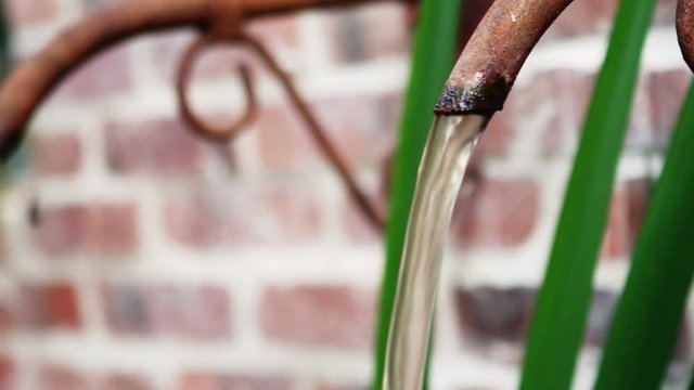 Water flowing from rustic pipe