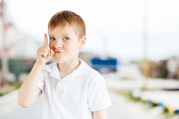 Little boy show emotions at park background with light