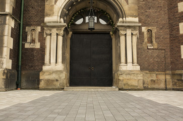 Wrought iron door with a pattern near the brick wall