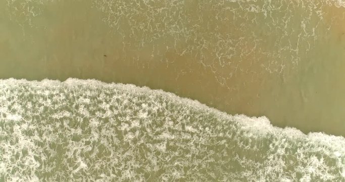 Aerial drone footage of the waves reaching shore. Drone smoothly follows the wave. Phuket.Thailand 2017.