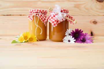 honey with flowers on wooden background