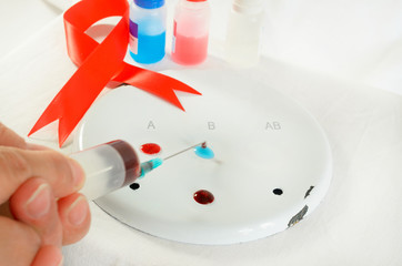 Blood sampling and analysis in a biochemical laboratory on a light background. A plate with a...