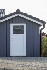 Weiße Tür mit grauer Holzwand