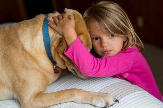 Young Child Hugging Dog