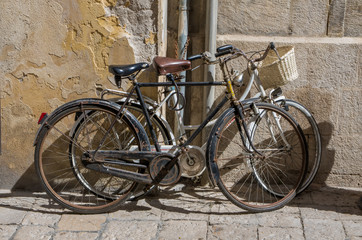 Alte Fahrräder lehnen an Hauswand in Italien