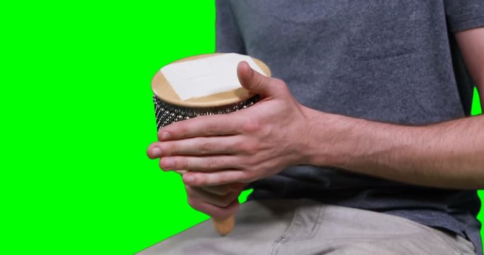 Mid section of male musician playing cabasa
