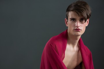 Androgynous man wrapped in red clothes