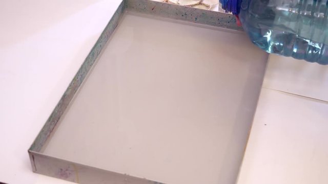 Closeup of water pouring to the bowl for creating ebru picture