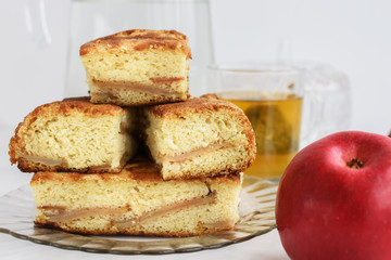 Apple pie and red apple on white table