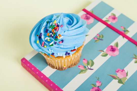 Tasty cupcake on notebook