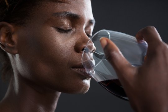 Androgynous person drinking wine from glass - Powered by Adobe