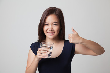 Young Asian woman thumbs up with a glass of drinking water.