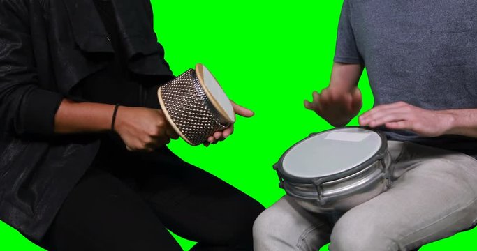 Mid section of musicians playing cabasa and drum