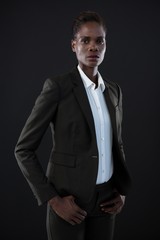 Androgynous man in suit posing against grey background