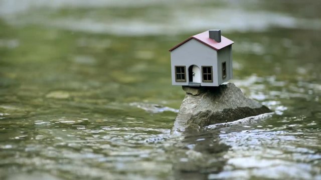 Model house on a rock and in the river.