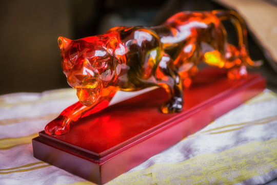 Glass figure of puma on the wooden basement