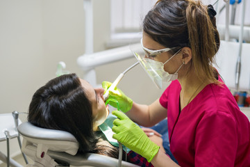 Obraz na płótnie Canvas Female stomatologist treating woman's teeth in dental clinic