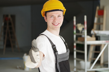 Handwerker positiv lächelnd auf einer Baustelle 
