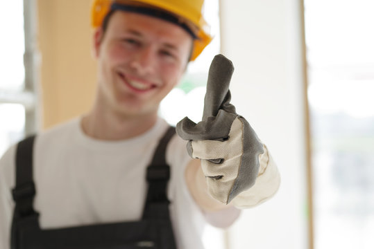Handwerker positiv lächelnd auf einer Baustelle 