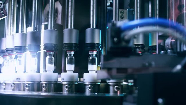 Pharmaceutical machine. Automated quality control equipment. Medical vials on production line at pharmaceutical factory. Pharmaceutical technology. Quality control at pharmaceutical industry