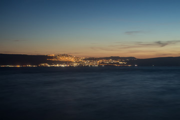 Fototapeta na wymiar Night view of Tiberias from the opposite shore of Kinneret Lake