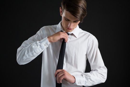 Androgynous man adjusting his tie