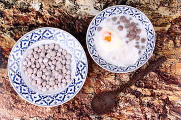 Purple potato dumplings with poached egg and coconut roll in sweet coconut cream .