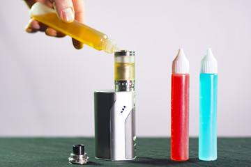 man hand flowing liquid to e cigarette tank composition photograph