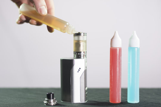 Man Hand Flowing Liquid To E Cigarette Tank Composition Photograph