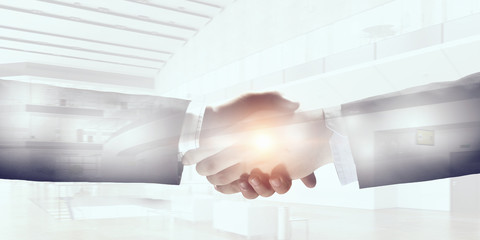 Business handshake as symbol of deal . Mixed media