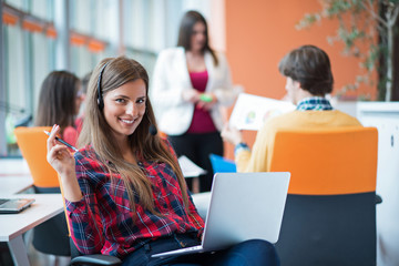 happy young business woman with her staff, people group in background at modern bright office indoors
