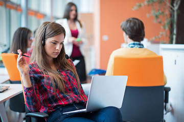happy young business woman with her staff, people group in background at modern bright office indoors