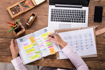 Businesswoman Writing Schedule In Calendar Diary - obrazy, fototapety, plakaty