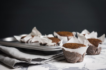 Fototapeta na wymiar Chocolate muffins on the rustic background. Selective focus.