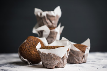 Chocolate muffins on the rustic background. Selective focus.