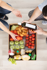 Couple With Groceries In The Cardboard Box