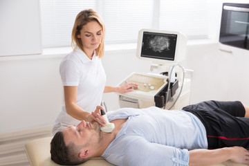 Female Doctor Performing Thyroid Ultrasound Test