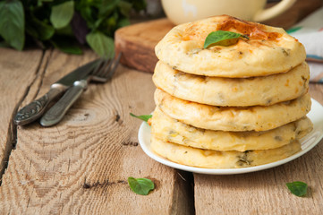 Potato herbs and cottage cheese small flat breads served on a wooden board. Copy space and vertical view.