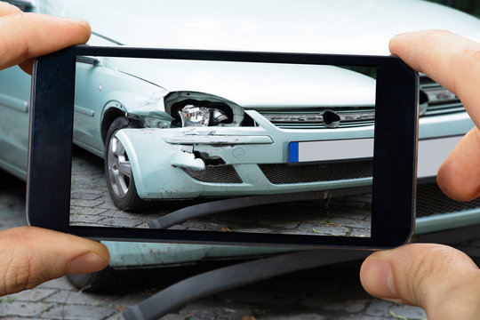 Person Capturing The Picture Of Broken Car