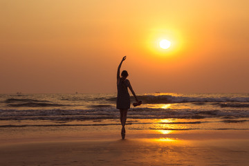 Amazing sunset portrait of the silhouette woman in Arambol beach, North Goa, India