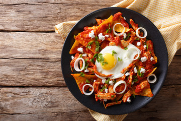 Mexican nachos with tomato salsa, chicken and egg close-up. Horizontal top view