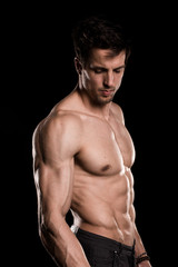 Fototapeta na wymiar Sexy Shirtless Muscular Male Model on Black Background